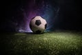 Traditional soccer ball on soccer field. Close up view of soccer ball (football) on green grass with dark toned foggy background. Royalty Free Stock Photo