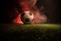 Traditional soccer ball on soccer field. Close up view of soccer ball (football) on green grass with dark toned foggy background. Royalty Free Stock Photo