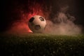 Traditional soccer ball on soccer field. Close up view of soccer ball (football) on green grass with dark toned foggy background. Royalty Free Stock Photo