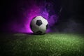 Traditional soccer ball on soccer field. Close up view of soccer ball (football) on green grass with dark toned foggy background. Royalty Free Stock Photo