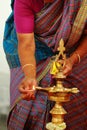 Traditional south Indian brass oil lamp with people, Hindu wedding rituals