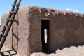 Traditional Southwestern Adobe building with rustic Ladder