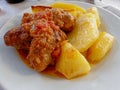 Traditional Souzoukakia gourmet Greek dish, small rolls of spicy minced meat with garlic in tomato sauce and baked potatoes.