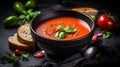 Traditional spanish cold tomato soup gazpacho in a bowl over black slate. Generative AI