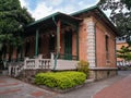 Traditional Spanish colonial house with green wood columns and large porch