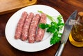 Traditional spanish dish. Butifarra, pork sausage with mushrooms on plate with herbs and cutlery