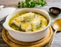 A traditional Spanish dish, hake in green sauce, served in a ceramic bowl on a rustic table Royalty Free Stock Photo