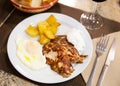 Traditional spanish fried pork with potato and egg on plate. Cerdo patata eggs