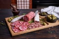 Traditional Spanish fuet salami sausage on wooden cutting board at domestic kitchen Royalty Free Stock Photo