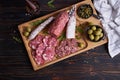 Traditional Spanish fuet salami sausage on wooden cutting board at domestic kitchen Royalty Free Stock Photo