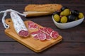 Traditional Spanish Fuet thin dried sausage with slices on a wooden board Royalty Free Stock Photo