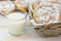 Traditional Spanish or Philippine pastry ensaimada. Powdered, on cooling rack and in wicker basket. Glass of milk