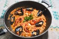 Traditional spanish seafood paella or arroz caldoso inside black pan with shrimps, mussels, clams and parsley. Homemade Royalty Free Stock Photo