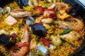 Traditional spanish seafood paella dish in a black pan. Mussels, Amandi and prawns on a pillow of rice. Close-up. Royalty Free Stock Photo