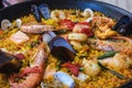 Traditional spanish seafood paella dish in a black pan. Mussels, Amandi and prawns on a pillow of rice. Close-up. Royalty Free Stock Photo