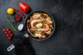 Traditional spanish seafood paella in pan rice, peas, shrimps, mussels and squid on black background, flat lay with copy space Royalty Free Stock Photo