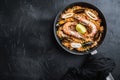 Traditional spanish seafood paella in pan rice, peas, shrimps, mussels and squid on black background, flat lay with copy space Royalty Free Stock Photo