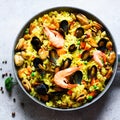 Traditional spanish seafood paella in pan rice, peas, shrimps, mussels, squid on light grey concrete background. Top Royalty Free Stock Photo