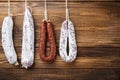 Traditional spanish smoked sausages meat hanging on light wooden background, flat lay Royalty Free Stock Photo