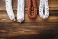 Traditional spanish smoked sausages meat hanging on light wooden background, flat lay with copy space Royalty Free Stock Photo