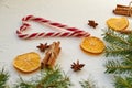 Traditional spices for mulled wine on the white concrete table: anise stars, cinnamon sticks, dried oranges. Heart of candy cones