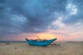 Traditional Sri Lankan fishing boat on sandy beach at sunset. Royalty Free Stock Photo