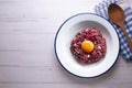 Traditional steak tartare with beef and egg yolk. Traditional Spanish tapas.