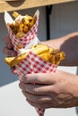 Traditional street food in Belgium and Netherlands, French fried potatoes chips with mayonnaise sauce in paper cone bag