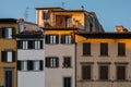 Traditional street houses of Florence with shabby yellow walls and brown and green shutters on the windows. Old Royalty Free Stock Photo