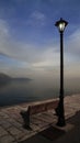 atmospheric view with a street light and a bench in the port in the sunset, Itea, Greece Royalty Free Stock Photo