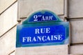 Traditional street name plate of Paris, France, on which reads `French Street` written in French Royalty Free Stock Photo