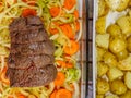 A traditional Sunday Roast meal of a topside roast beef joint and potatoes with herbs and olive oil