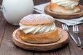 Traditional swedish dessert Semla, also called Shrove bun, with almond paste and whipped cream filling, served with milk,