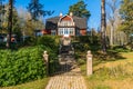 Traditional Swedish wooden house villa cottage red color. Two storey country house with balcony. Metal cast gate entrance to Royalty Free Stock Photo