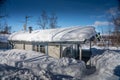 Traditional swedish wooden log cottage in winter forest with frost and snow in sunny day Royalty Free Stock Photo