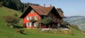 Traditional swiss manor red country house nestled in lush green swiss countryside Royalty Free Stock Photo