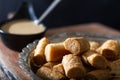 Traditional tahini crispy roll with bowl of tahini on wooden background. Dry Baklava with Tahini or Tahini Crispy
