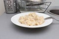 Traditional tasty hot boiled russian pelmeni, ravioli, dumplings with meat on white ceramic plate in kitchen interior after Royalty Free Stock Photo