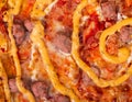 Traditional tasty salsiccia pizza with beef sausages, mozzarella, various sauces and marinated red onions, close up view Royalty Free Stock Photo