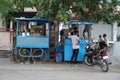 Traditional tea house in the streets of India. Tea vendor preparing tea and buyer maintaining distance with mask on face. India Royalty Free Stock Photo