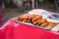 Traditional Thai charcoal roasted pork sausages in food tray on food market stall. Asian Thai street food, cuisine, gourmet,