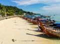 Traditional Thai fishing wooden boats wrapped with colored ribbons. At sand coast of tropical island