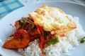 Traditional thai food cuisine shrimp or prawn fried spicy red curry with vegetable on cooked rice and topping fried egg on ceramic Royalty Free Stock Photo