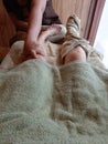 Traditional Thai foot massage. Masseuse does massage woman`s leg and wrap another foot by towel Royalty Free Stock Photo