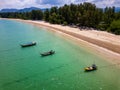 Traditional Thai Longtail fishing boats anchored off a small, palm tree lined tropical beach (Khao Lak, Thailand Royalty Free Stock Photo