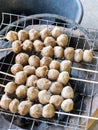 The traditional Thai style pork meatballs with the skewers are grilled on a metal grid Royalty Free Stock Photo