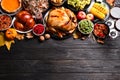 Traditional Thanksgiving day feast with delicious cooked turkey and other seasonal dishes on black wooden table, flat lay. Space Royalty Free Stock Photo