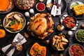 Traditional Thanksgiving day feast with delicious cooked turkey and other seasonal dishes served on black wooden table, flat lay Royalty Free Stock Photo