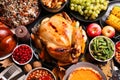 Traditional Thanksgiving day feast with delicious cooked turkey and other seasonal dishes served on black wooden table, flat lay Royalty Free Stock Photo