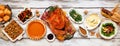 Traditional Thanksgiving turkey dinner above table scene on a rustic white wood banner